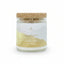 Candle in a glass jar with a cork lid labeled 'Abundance' on a white background