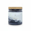 Candle jar with cork lid and 'Moons' label on a white background